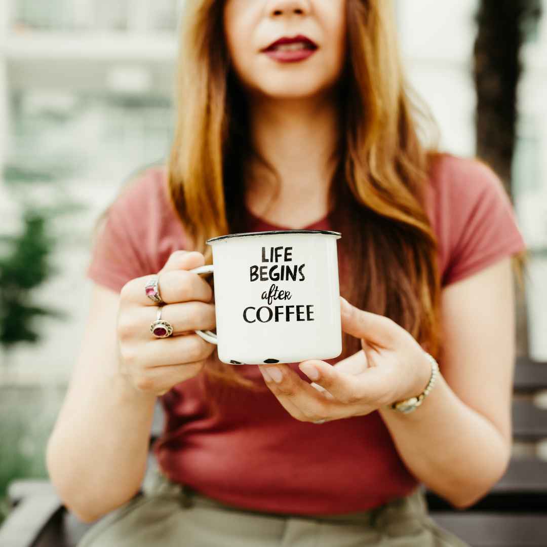 a woman holds a cup of coffee that reads life begins after coffee